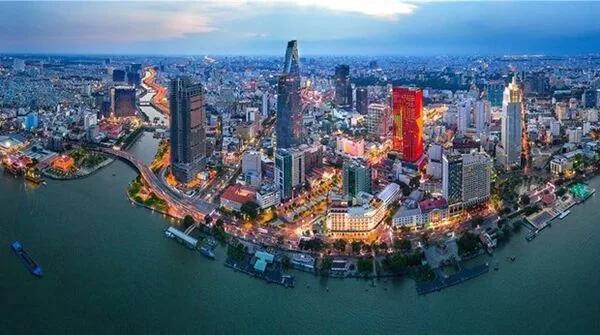 Vue aérienne nocturne d’une grande ville vietnamienne longeant une rivière